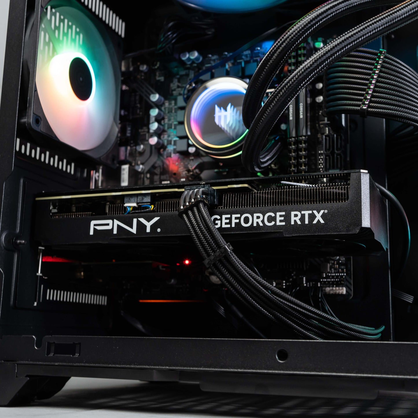 Gaming PC with PNY GeForce RTX and RGB lighting displaying internal components with advanced cooling.