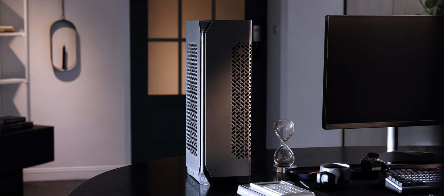 Modern minimalist computer setup with black desk, sleek PC tower, monitor, accessories, and decor in a stylish home office.